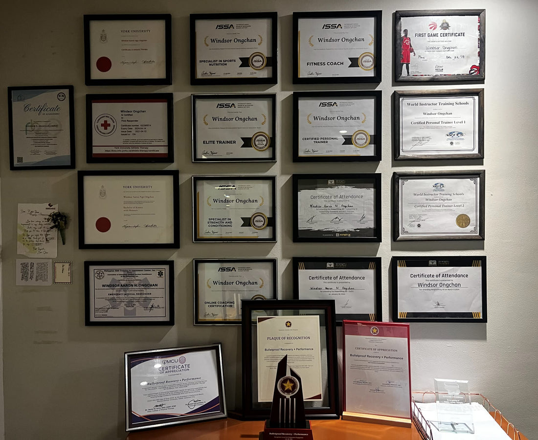 Wall of the founder's framed certifications, with the clinic's university awards displayed below, at the Bulletproof clinic