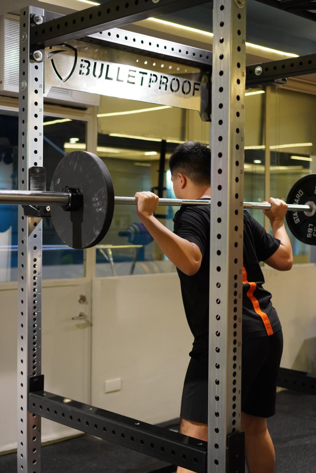 Athlete squatting under a Performance Specialist's supervision at Bulletproof